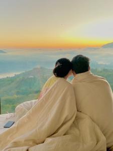 a man and woman sitting on top of a mountain at Devanora Hotel & Resto in Kintamani
