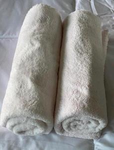 duas toalhas brancas em cima de uma cama em Orchard Apartment Pakuwon Mansion 2 by Shinzhouz em Surabaya