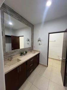 La salle de bains est pourvue de 2 lavabos et d'un grand miroir. dans l'établissement Casa Portobello, à La Paz