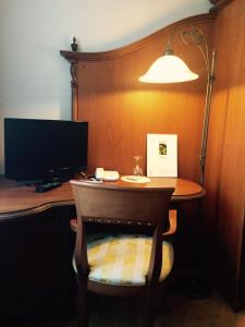 a desk with a computer monitor and a lamp at Hotel Goldner Loewe in Bad Köstritz