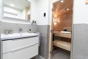 y baño con lavabo blanco y espejo. en Dorumer Sielhuus 20 mit Sauna und Balkon, en Dorum
