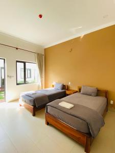 a bedroom with two beds and a large window at ARECA MUINE HOMESTAY in Phan Thiet