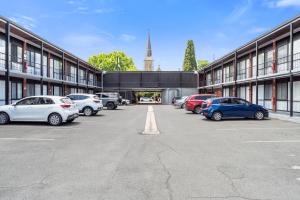 a parking lot with cars parked in front of a building at Commodore Motor Inn in Albury