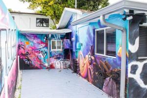 ein Gebäude mit Graffiti auf der Seite in der Unterkunft Cozy & Colorful Miami Art Canvas w/HotTub & Murals in Miami