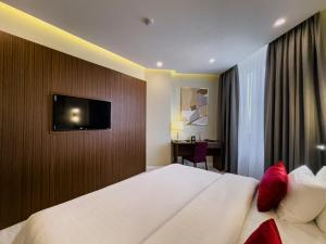 a hotel room with a bed and a tv on a wall at Kazakhstan Hotel in Almaty