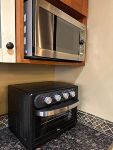 a microwave above a stove in a kitchen at Solara Mountain Retreat - Pool - Hot Tub - Spa - Gym in Canmore