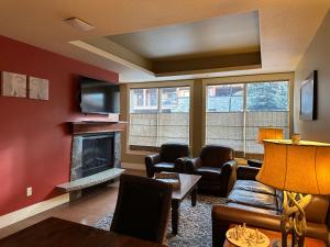 a living room with a couch and a fireplace at Solara Escape - 2BR Retreat with Pool - Hot Tub - Gym - Spa in Canmore