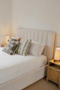 een slaapkamer met een wit bed met kussens erop bij Breeze Mooloolaba, Ascend Hotel Collection in Mooloolaba