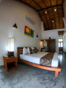 a bedroom with a bed and a night stand with a lamp at Elephant Trail in Udawalawe