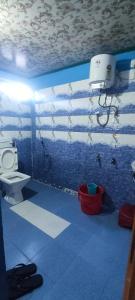 uma casa de banho com um WC e uma parede azul em TAMANG FAMILY HOMESTAY VL BED & BREAKFAST, DARJEELING em Darjeeling