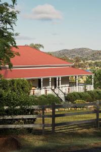 Casa blanca con techo rojo y valla en The Homestead at Ballandean Lodge, en Ballandean