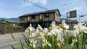 富士河口湖的住宿－Holiday home Furinkazan，街道前有白色花的房屋