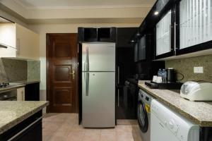een keuken met een koelkast in het midden bij Zamalek Serviced Apartments by Brassbell in Caïro
