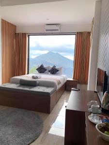 a bedroom with a bed with a large window at Devanora Hotel & Resto in Kintamani