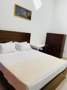 a bedroom with a large white bed and a desk at White Villa in Weligama