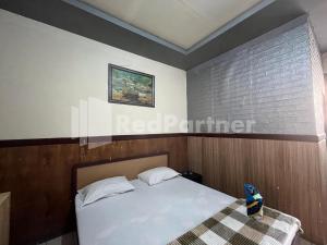 a bedroom with a white bed and a window at Hotel Dewi RedPartner near Gor Merdeka Jombang in Jombang