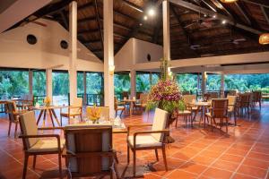 a restaurant with tables and chairs and windows at Pax Ana Doc Let Resort & Spa in Ninh Hòa