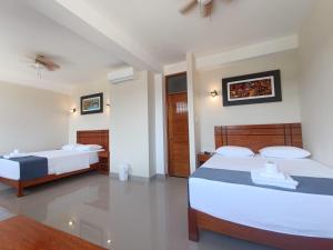 1 dormitorio con 2 camas en una habitación en Hotel Inambari Golden, en Chiforongo