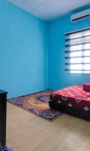 a room with a bed and a rug on the floor at Teratak Kayu Homestay in Batu Pahat