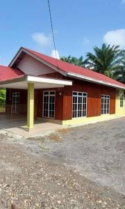 um edifício vermelho e amarelo com um telhado vermelho em Teratak Kayu Homestay em Batu Pahat