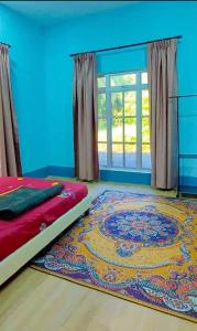 a bedroom with a bed and a rug on the floor at Teratak Kayu Homestay in Batu Pahat