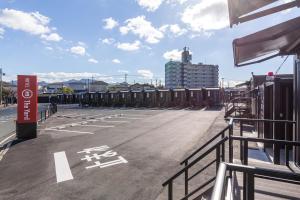 NakamaHOTEL R9 The Yard Nakama的一个空的停车场,后面有一座建筑