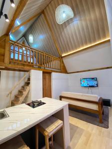 sala de estar con techo de madera y escalera en Martos villa dieng, en Diyeng