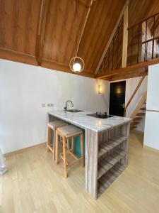 uma cozinha com um balcão e um lavatório num quarto em Martos villa dieng em Diyeng