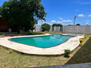 una piscina en un patio con un árbol en Txumas, en Maputo