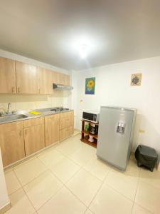 een keuken met een roestvrijstalen koelkast en houten kasten bij Hermoso apartamento en San Pablo Guayabal in Medellín