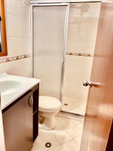 a bathroom with a shower and a toilet and a sink at Hermoso apartamento en San Pablo Guayabal in Medellín