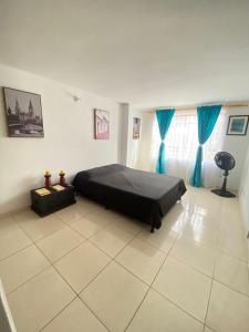 een slaapkamer met een bed in het midden van een kamer bij Hermoso apartamento en San Pablo Guayabal in Medellín