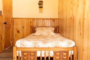 a bed in a room with wooden walls at CABAÑAS DULCE VISTA in Castro