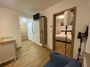 a living room with a blue couch and a bedroom at D-011 Bel appart calme climatisé parking privé gratuit sur demande in Charleroi