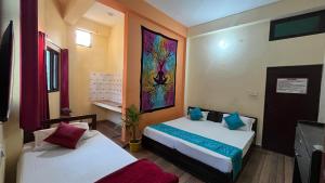 een kamer met 2 bedden en een schilderij aan de muur bij Tamraparni Rishikesh Stay in Rishīkesh