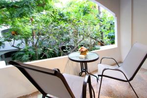 a table and two chairs and a window with trees at Pooh Beach Resort & Spa in Jomtien Beach