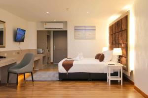 a hotel room with a bed and a desk at Pooh Beach Resort & Spa in Jomtien Beach