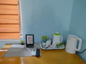 a table with two coffee makers and a remote control at Homestay Teratak D`kemangi with Private Pool in Baling