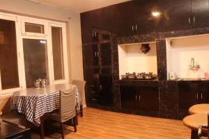 a kitchen with black cabinets and a table with chairs at Apartment Elegant Kathmandu in Kathmandu