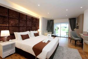 a bedroom with a large bed with a teddy bear on it at Pooh Beach Resort & Spa in Jomtien Beach