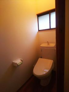 baño con aseo blanco y ventana en ”秩父の玄関口”横瀬駅より徒歩10分の民泊【武甲ステイ】, en Yokoze