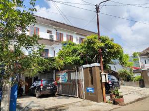 a house with cars parked in front of it at Penginapan Nurmega jaya in Lembursitu
