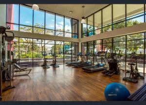 um ginásio com várias passadeiras e elípticos numa sala com janelas em Gorgeous 2BR Apt with City & Water views Southport em Gold Coast