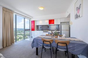 uma cozinha e sala de jantar com mesa e cadeiras em Gorgeous 2BR Apt with City & Water views Southport em Gold Coast