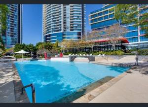 a large swimming pool in a city with tall buildings at Gorgeous 2BR Apt with City & Water views Southport in Gold Coast