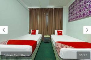 two beds in a hotel room with two beds sidx sidx sidx at SYAHIRAH HOTEL in Marang