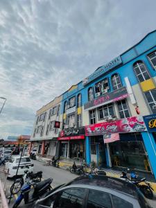a blue building with motorcycles parked in front of it at SYAHIRAH HOTEL in Marang