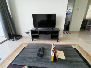 sala de estar con TV y 2 mandos a distancia en Sunshine Bay Resort Port Dickson, en Port Dickson