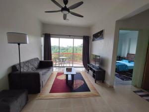 sala de estar con sofá y ventilador de techo en Sunshine Bay Resort Port Dickson, en Port Dickson