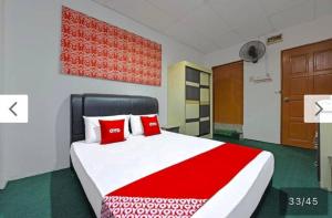 a bedroom with a large bed with red pillows at SYAHIRAH HOTEL in Marang